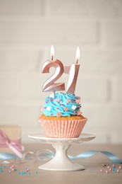 21th birthday. Delicious cupcake with number shaped candles for coming of age party on table