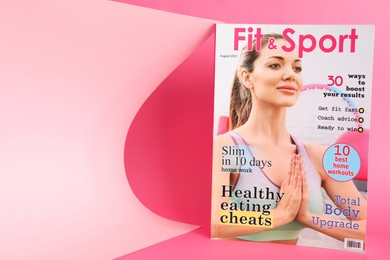 Modern printed sports magazine on pink background, space for text