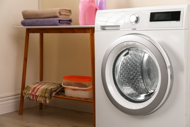 Modern white washing machine in laundry room