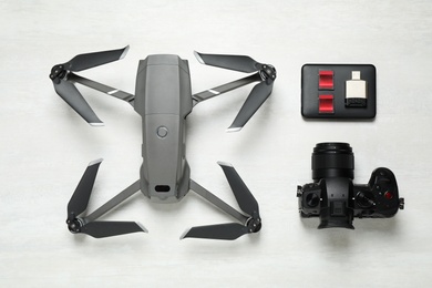 Modern drone, camera and video production equipment on white table, flat lay