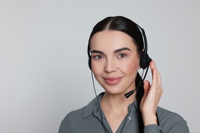 Photo of Hotline operator with modern headset on light grey background. Customer support