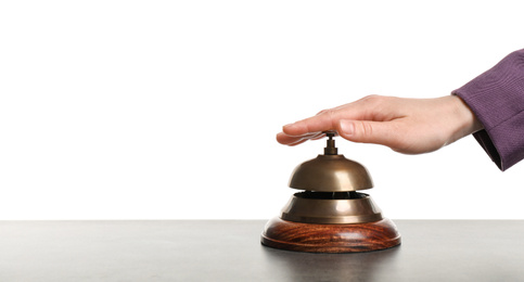 Woman ringing hotel service bell at grey stone table