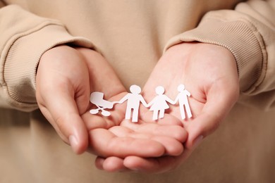 Photo of Man holding paper family figures, closeup. Insurance concept