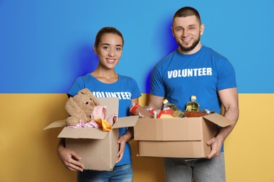 Volunteers holding donation boxes with Ukrainian flag on background. Help during war