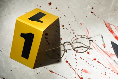 Crime scene marker, glasses and blood on light grey marble background, above view