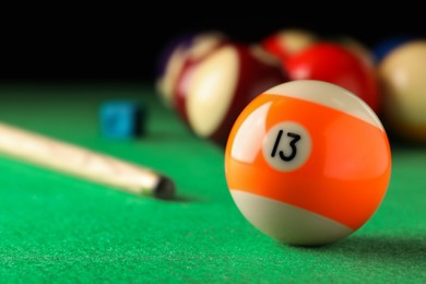 Billiard ball with number 13 on green table, closeup. Space for text