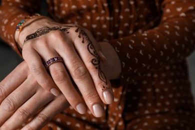 Woman with henna tattoo on hand, closeup and space for text. Traditional mehndi ornament