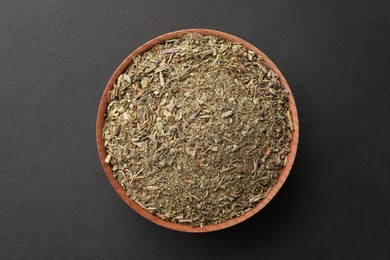 Bowl with dried thyme on grey background, top view
