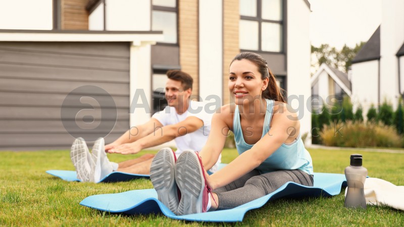 Sporty couple practicing morning yoga at backyard. Healthy lifestyle