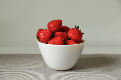 Fresh juicy strawberries in bowl on table