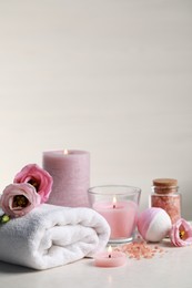 Photo of Beautiful composition with burning candles and different spa products on white table. Space for text