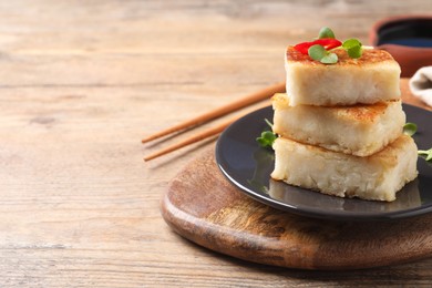 Delicious turnip cake with microgreens served on wooden table, closeup. Space for text