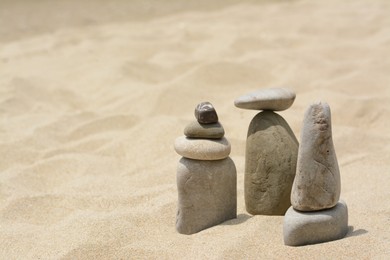 Stacks of stones on beautiful sandy beach, space for text