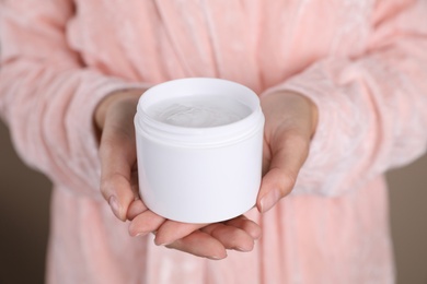 Woman with jar of moisturizing cream, closeup