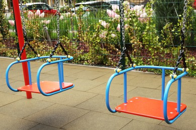 Photo of Swings on outdoor playground in residential area