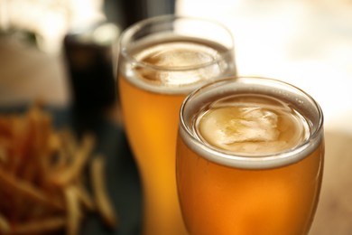Photo of Glasses of fresh cool beer in cafe, closeup