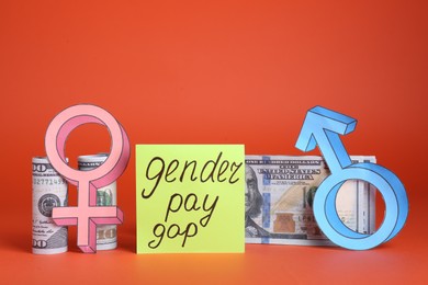 Photo of Gender pay gap. Male and female symbols near paper note, dollar banknotes on red background
