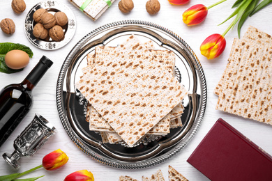 Flat lay composition with symbolic Pesach (Passover Seder) items on white wooden table