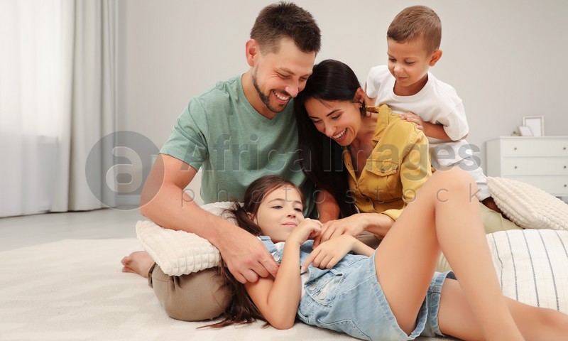 Happy family with children having fun on floor in bedroom