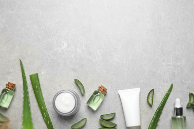 Flat lay composition with aloe vera and cosmetic products on grey background. Space for text