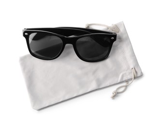 Stylish sunglasses with grey cloth bag on white background, top view