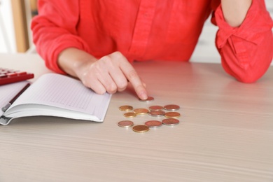Woman counting money at table indoors, closeup