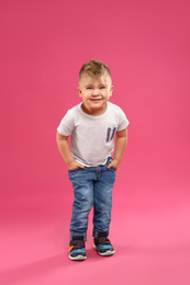 Cute little boy posing on pink background