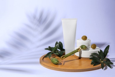 Photo of Cosmetic products, olives and jade roller on white background