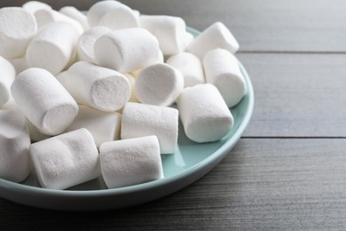 Delicious puffy marshmallows on wooden table, closeup