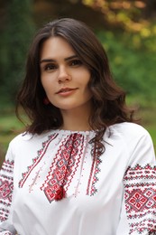 Beautiful woman in embroidered shirt outdoors. Ukrainian national clothes