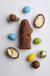 Flat lay composition with chocolate Santa Claus and sweets on white background