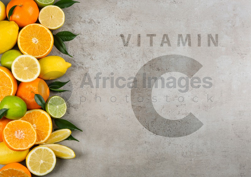 Source of Vitamin C. Flat lay composition with tangerines and different citrus fruits on grey background