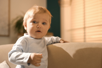 Photo of Cute little baby with on sofa indoors