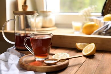 Delicious tea, sugar and lemon on wooden table, space for text