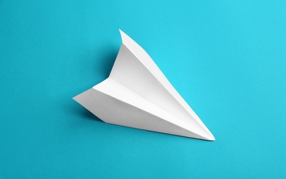 White paper plane on light blue background