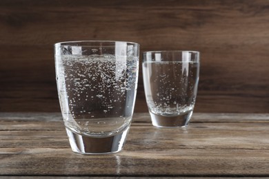 Glasses of soda water on wooden table. Space for text
