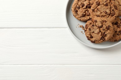 Delicious chocolate chip cookies on white wooden table, top view. Space for text