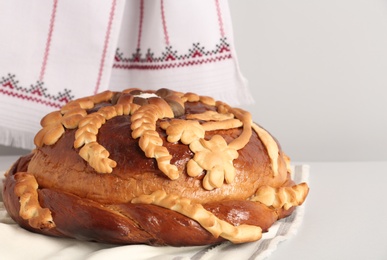 Korovai on white table against light background. Ukrainian bread and salt welcoming tradition