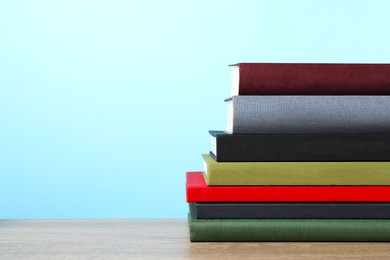 Photo of Stack of hardcover books on wooden table, space for text