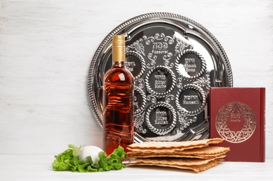 Symbolic Passover (Pesach) items on table against wooden background, space for text