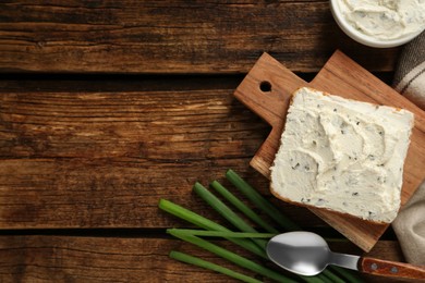 Photo of Delicious sandwich with cream cheese and chives on wooden table, flat lay. Space for text
