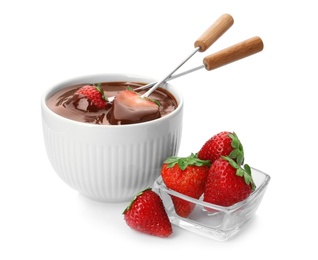 Photo of Fondue forks with strawberries in bowl of melted chocolate on white background
