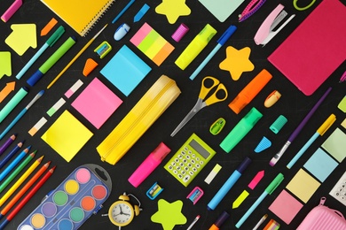 Flat lay composition with different school stationery on blackboard. Back to school