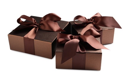 Brown gift boxes decorated with satin ribbon and bows on white background