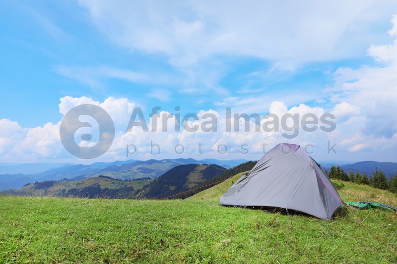 Photo of Small camping tent in mountains on sunny day