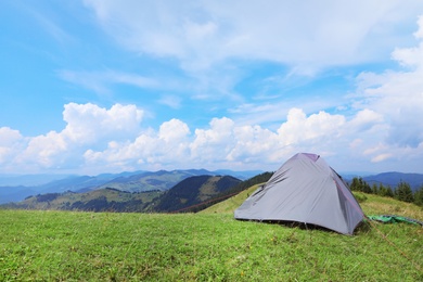 Small camping tent in mountains on sunny day