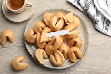 Photo of Tasty fortune cookies and paper with prediction on wooden table, flat lay. Space for text