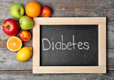 Flat lay composition with word DIABETES and fruits on wooden background