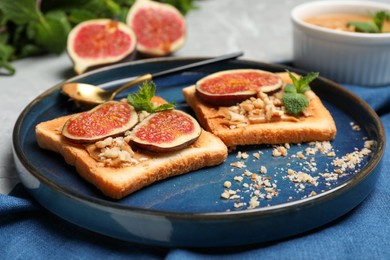 Tasty toasts served with fig, peanut butter and walnuts on light grey table, closeup
