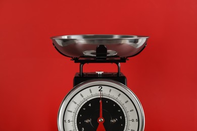 Retro mechanical kitchen scale on red background, closeup